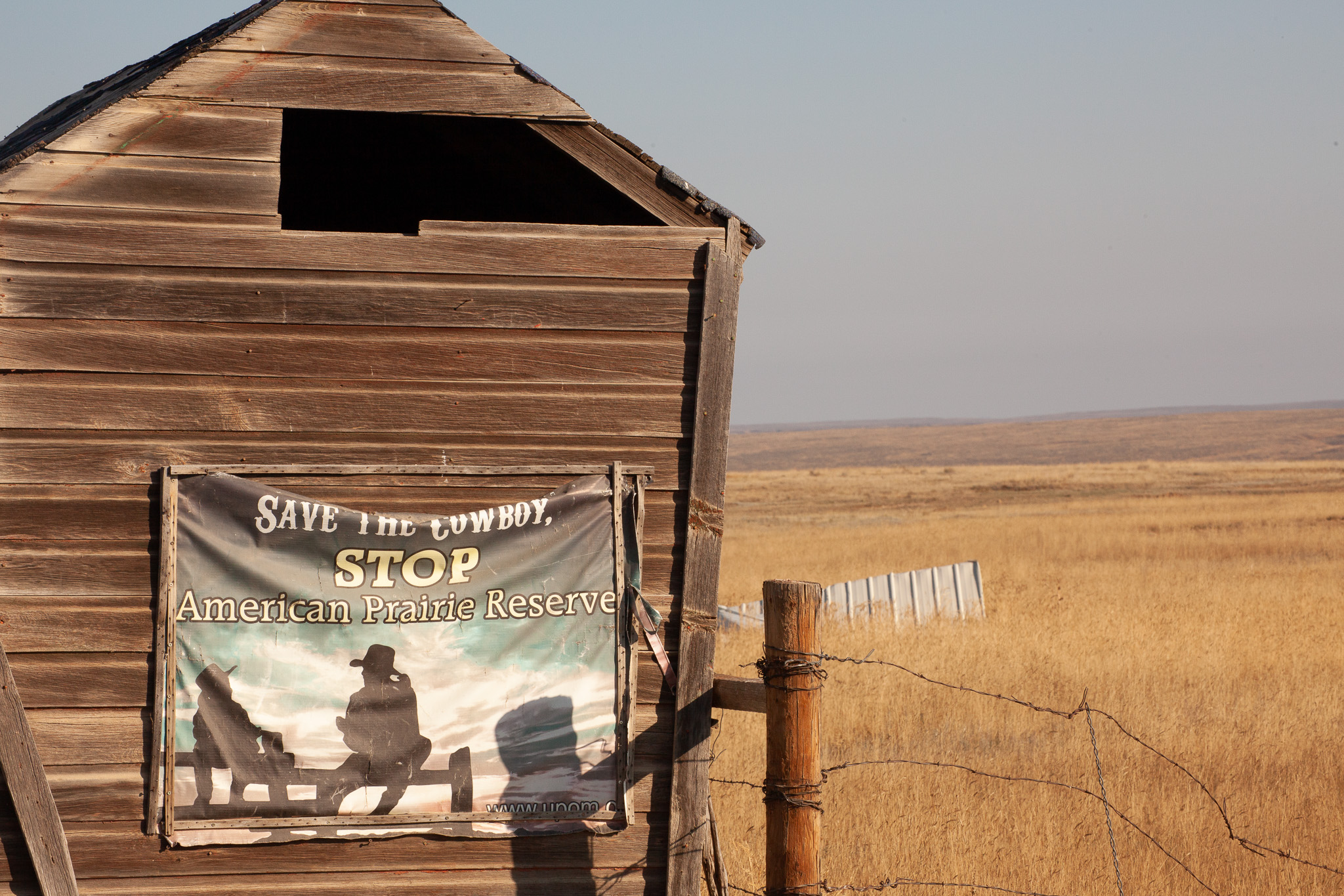 An anti-American Prairie Reserve sign on the wall of an old barn.