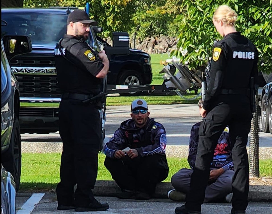 Chase Cominsky sits on a curb and talks to police.