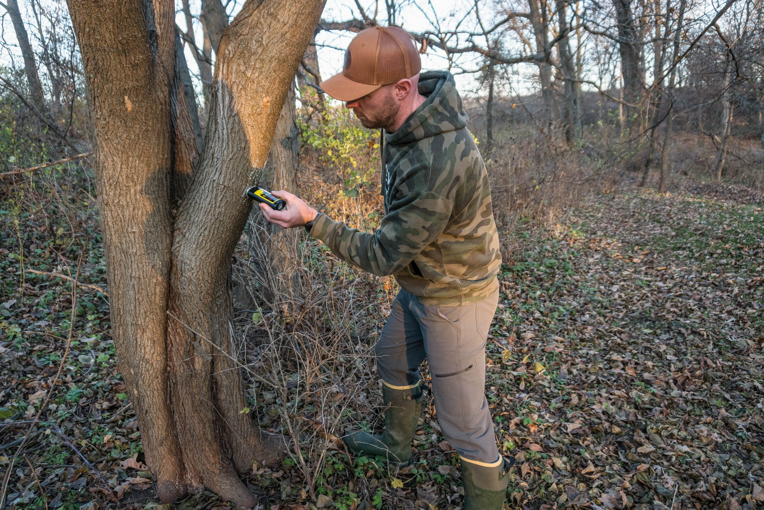 The author applies Ever Calm, one of the best deer attractants to a tree.