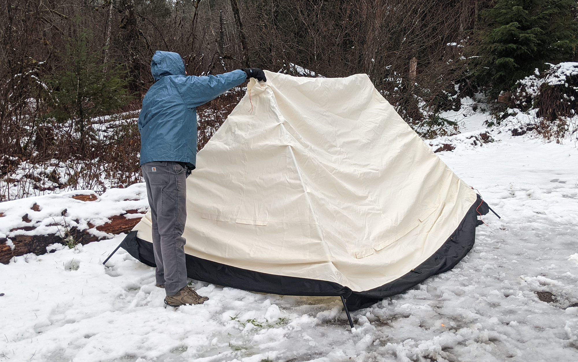 Draping the tent body over the sawhorse configuration in our slush-filled campsite. 