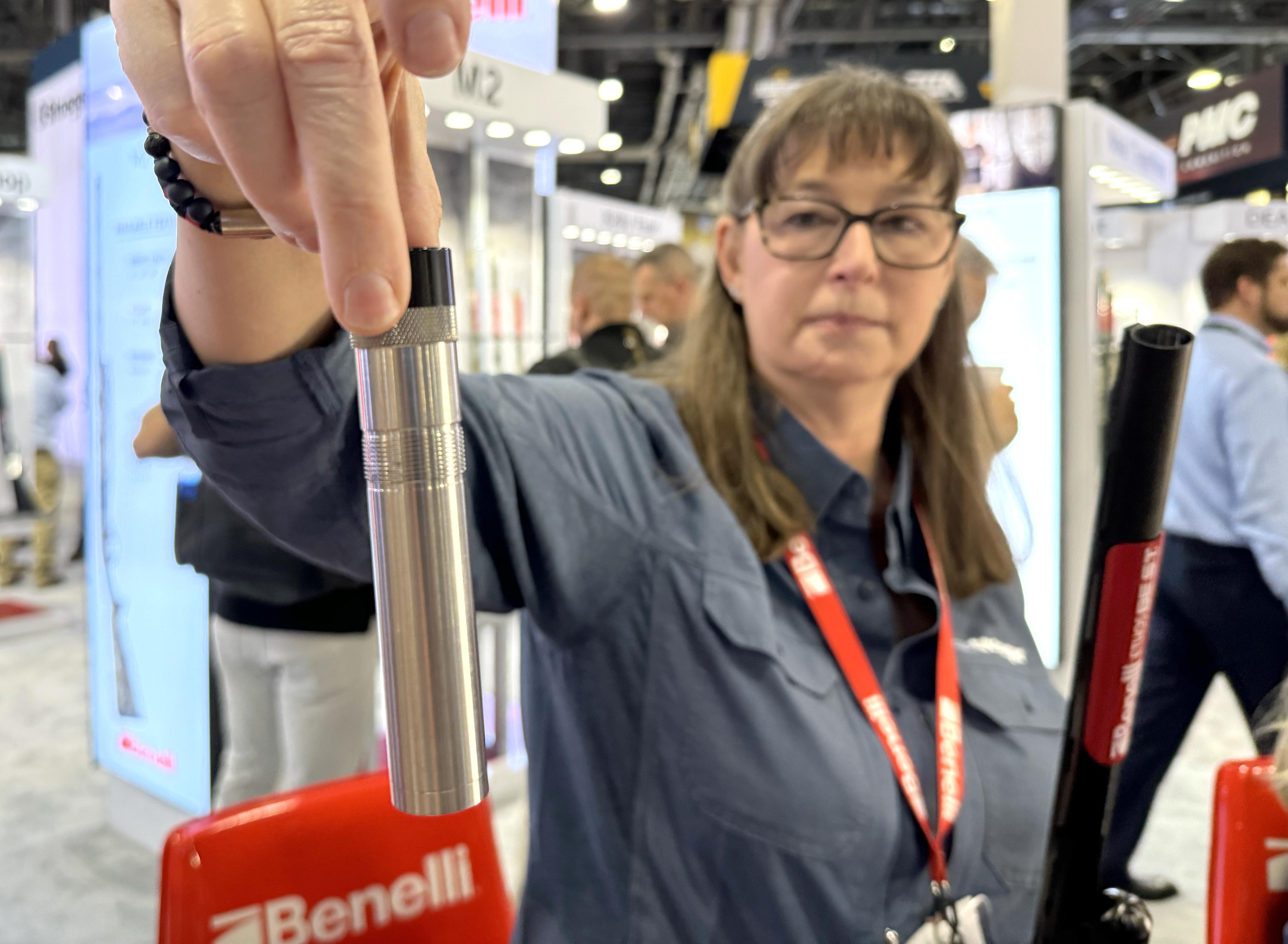 A Benelli employee holds a silver choke tube.