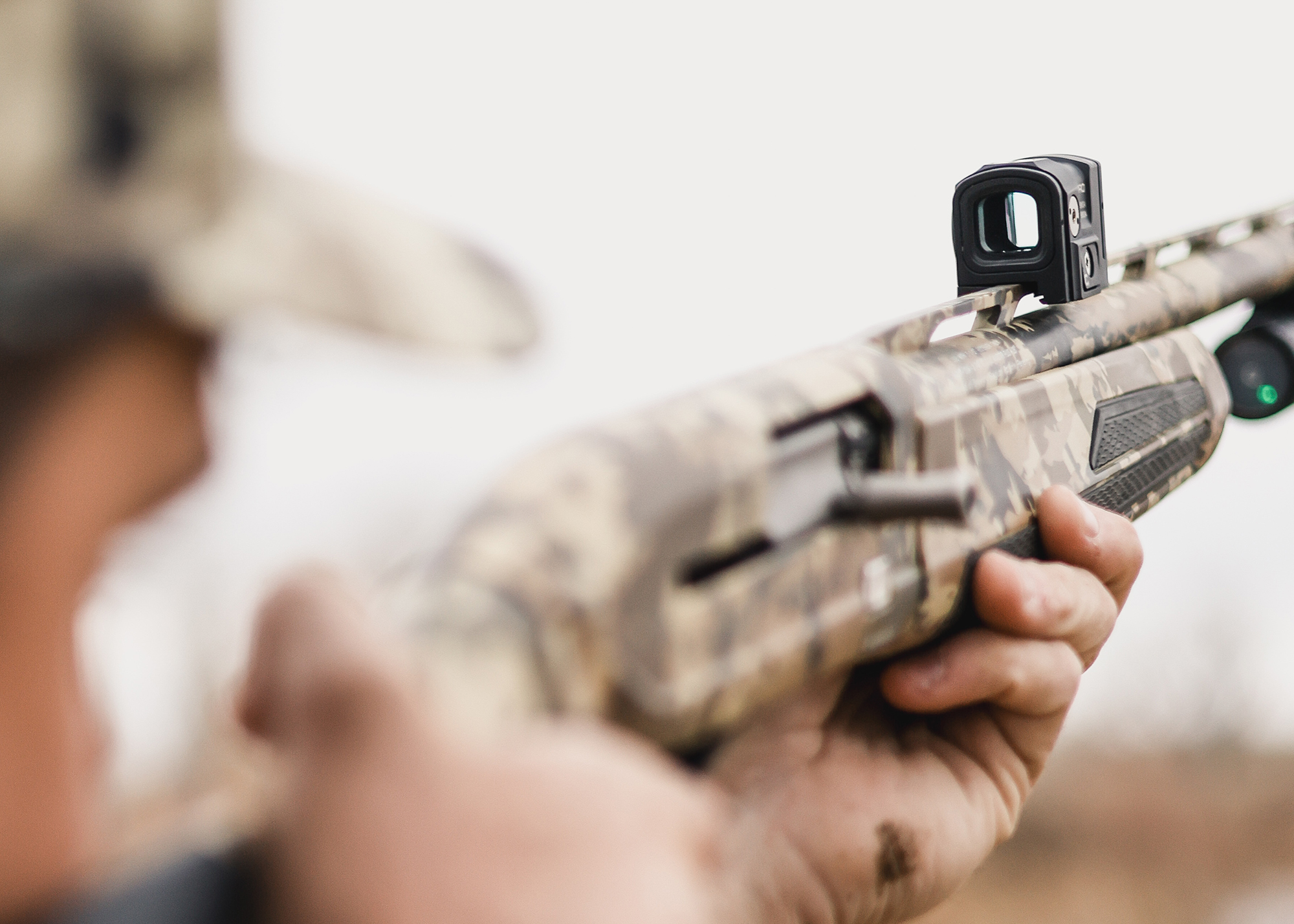 A hunter looks through a red-dot sight on a duck gun.