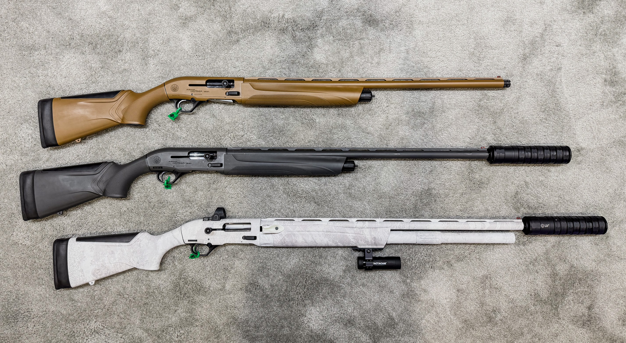 Three waterfowl shotguns made by Beretta, lying on a carpet at SHOT Show 2024.