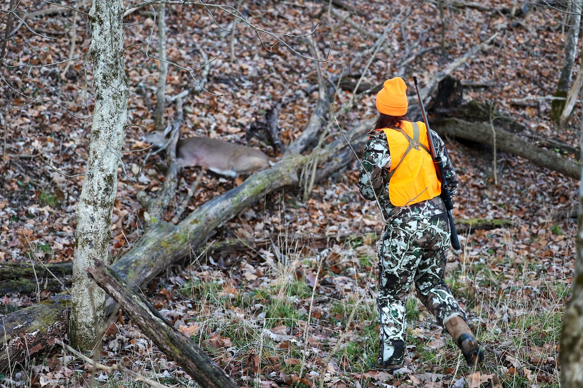 A new hunter approaches her first deer.