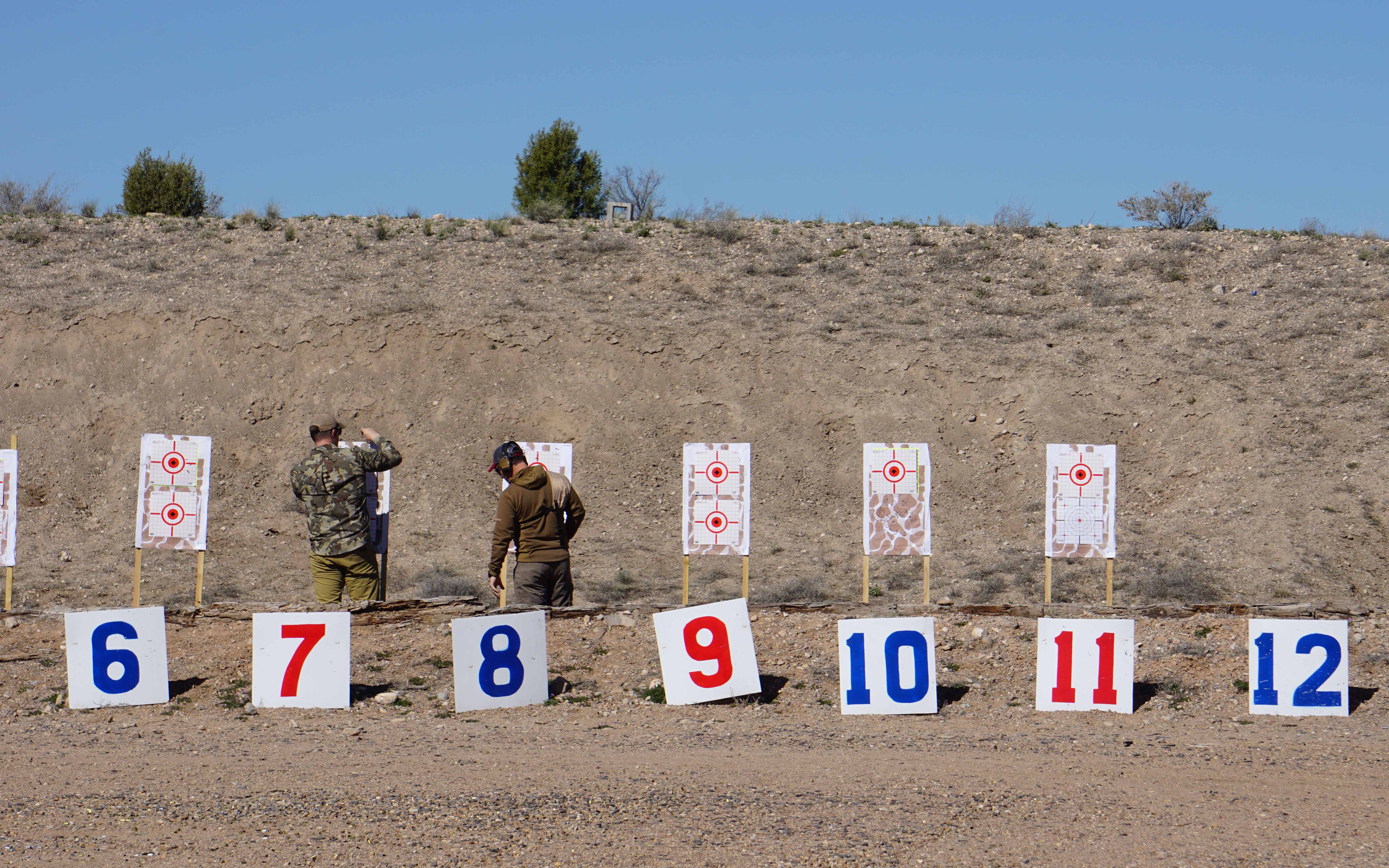 Two recreational shooters change targets.