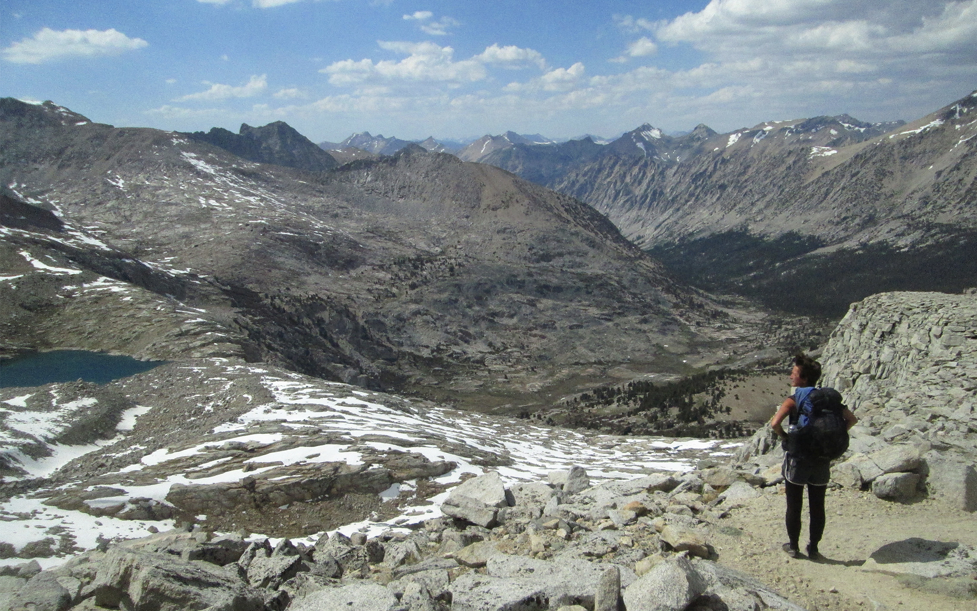 Woman looks at view at the top of a JMT trail pass