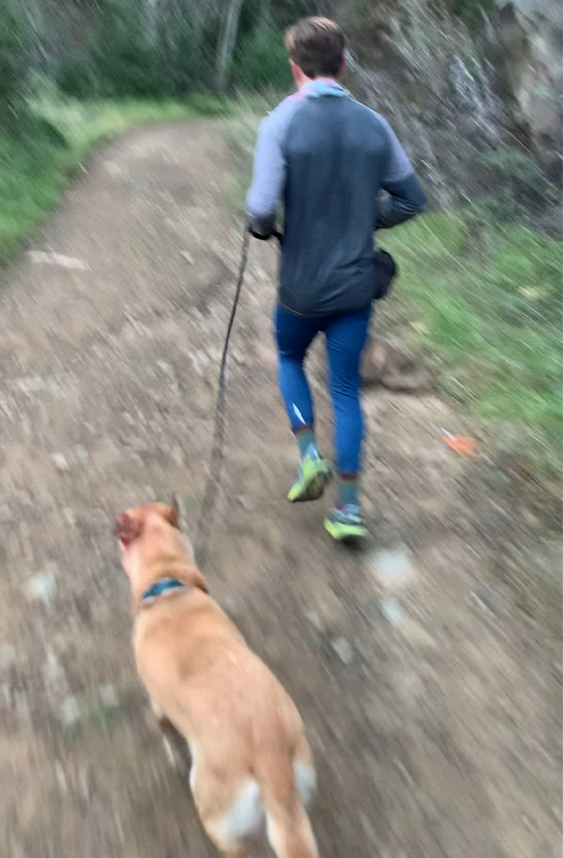 A trail runner and his dog on a trail in southern California.