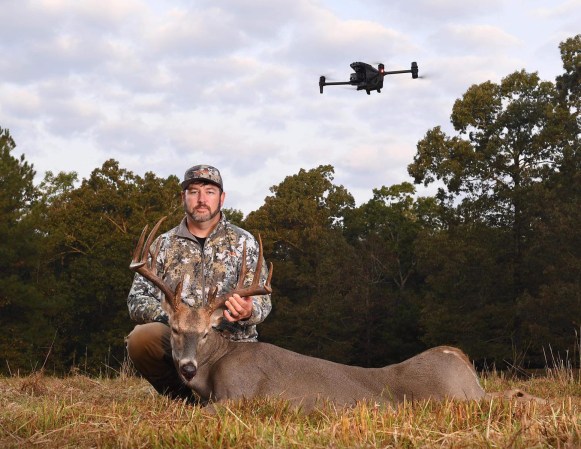 A Tennessee hunter with a buck and a drone flying overhead.