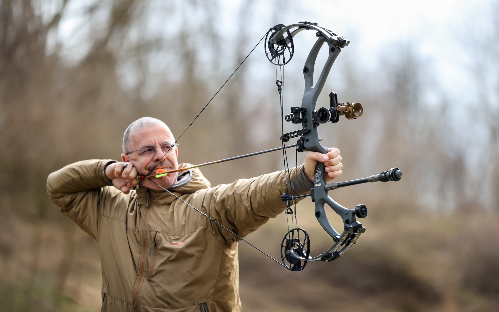 Bowhunter and archer PJ Reily holds the PSE Mach 30 compound bow at full draw.