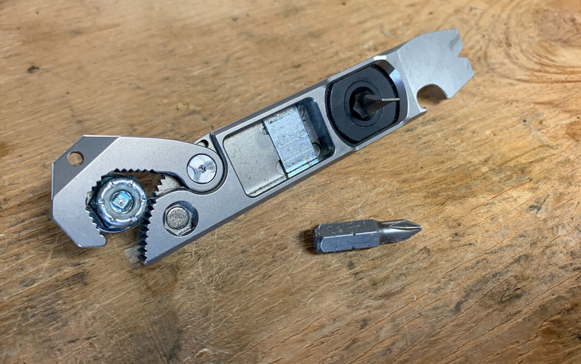 The ResafeLY Titanium Pry Bar EDC Tool  features a pry bar wedge with nail notch, ¼-inch ratcheting driver, magnetic two-bit retaining recess, flat and Phillips bits, magnetic driver socket, bottle opener, and small universal wrench.