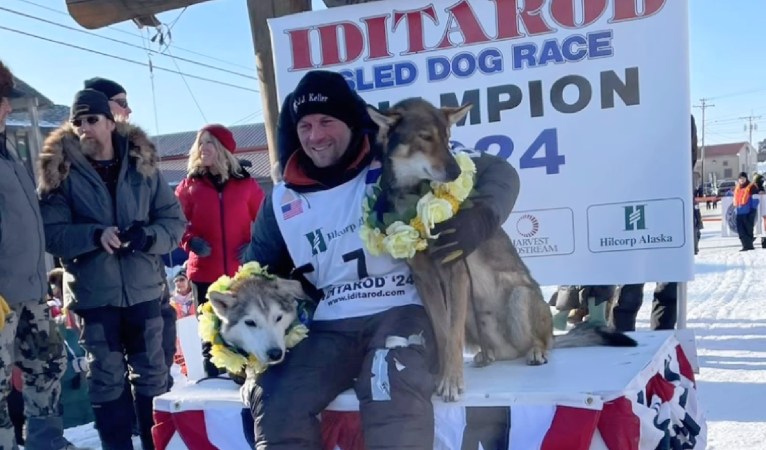 Dallas Seavey poses with his dogs at the Iditarod finish line.