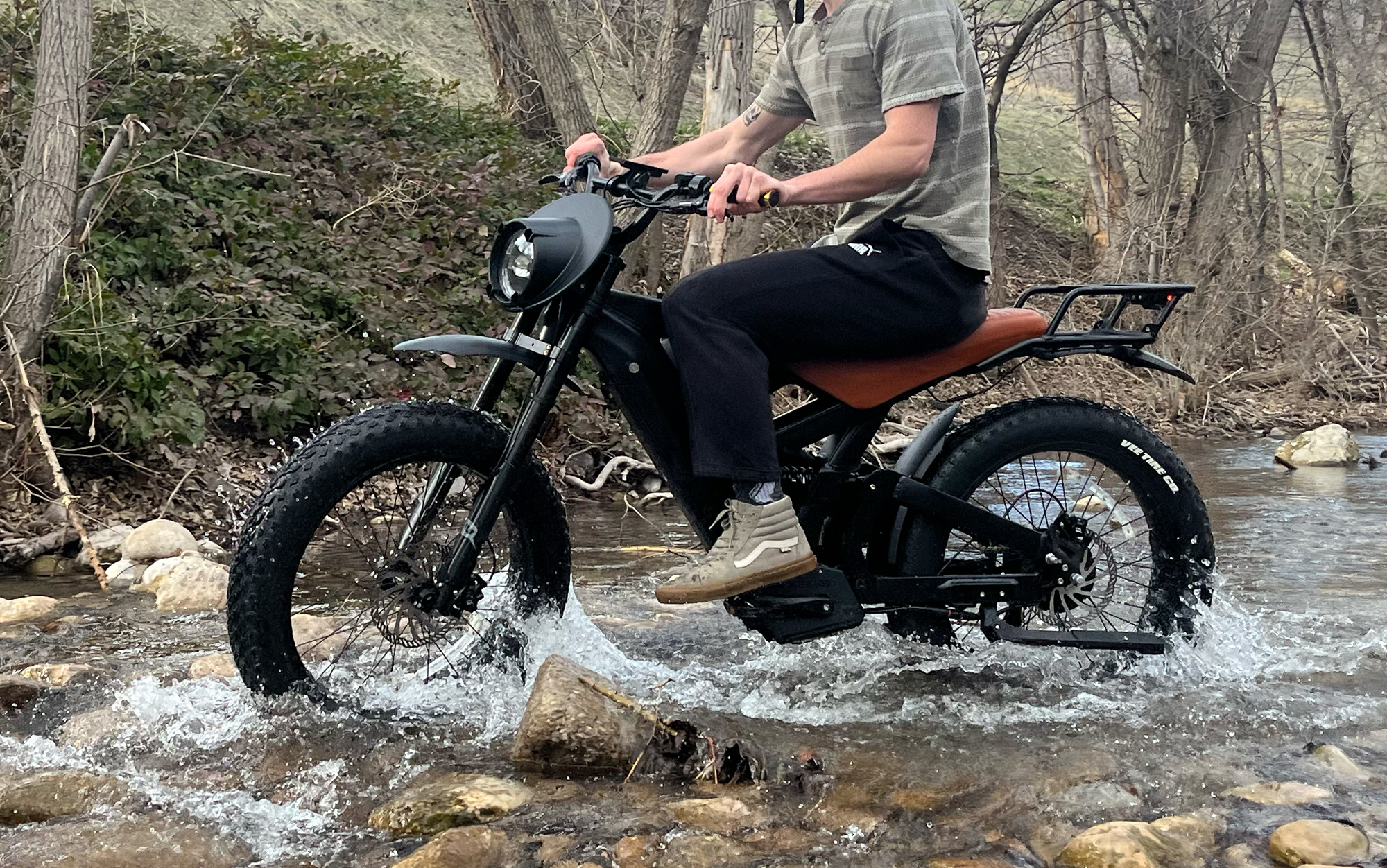 Tester rides fat tire electric bike over stream.