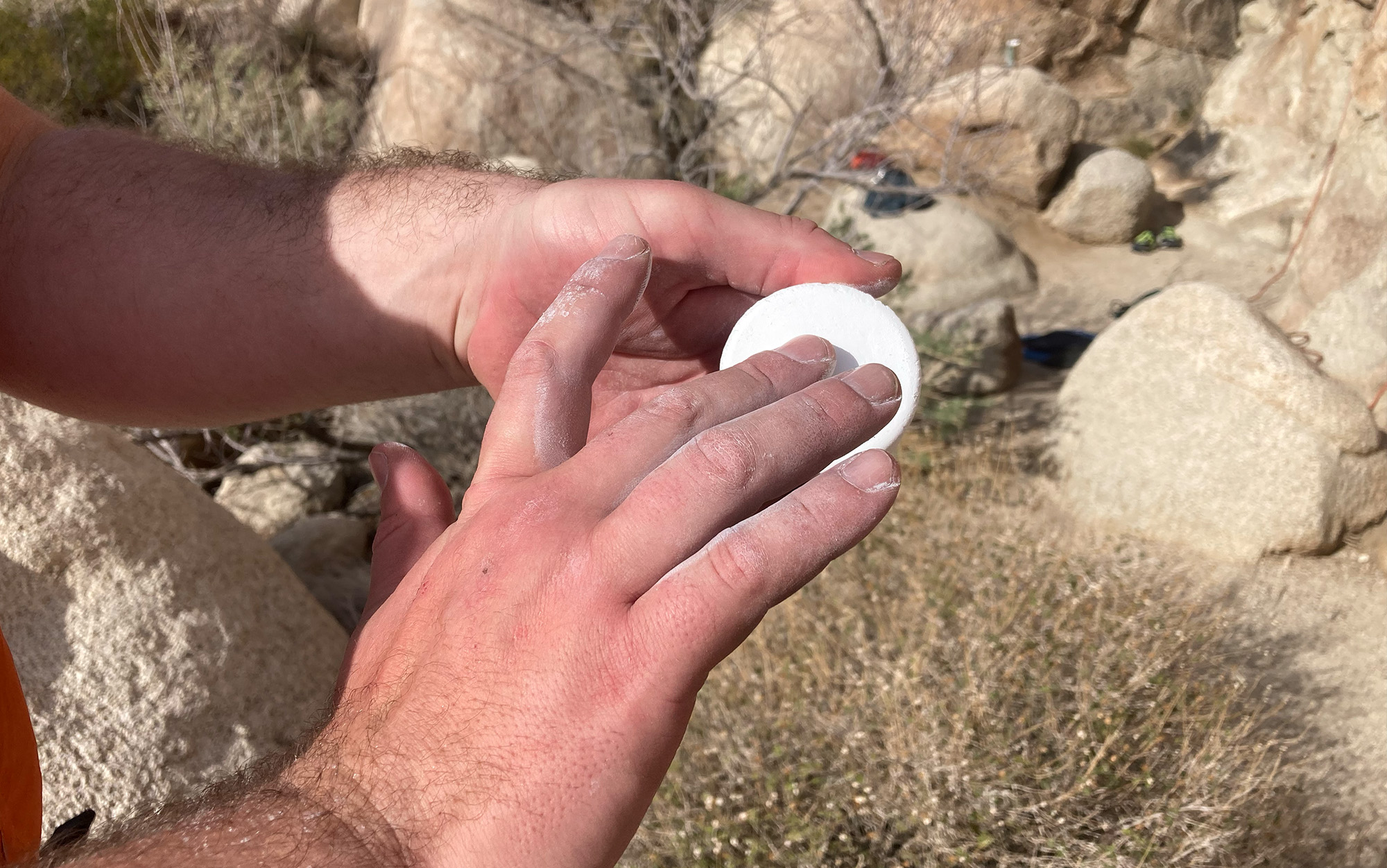 Climber chalks up with disc.
