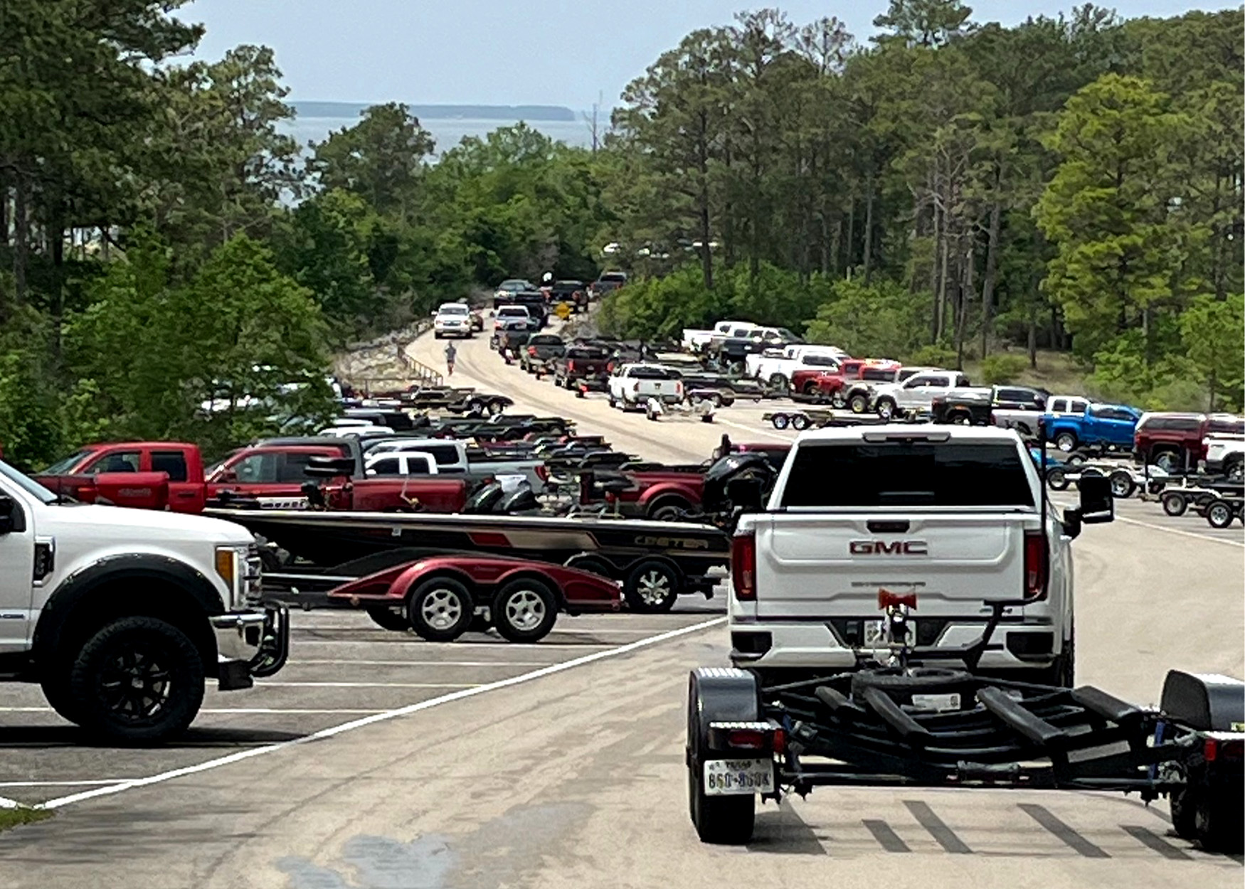 A line of boats and trailers at a fishing tournament.