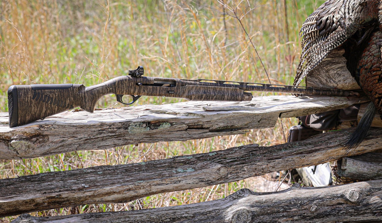 The Benelli M2 Turkey Performance Shop shotgun resting on a split rail fence.