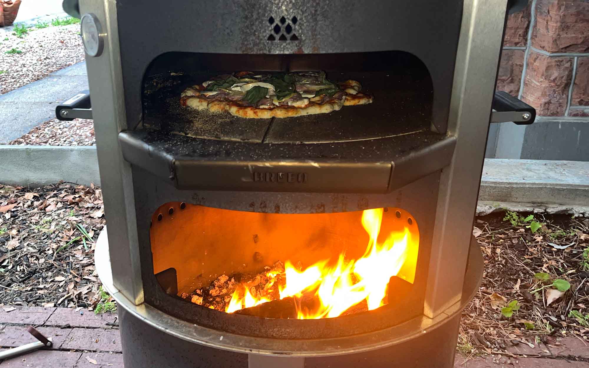 A pizza cooks in the Breeo Live-Fire pizza oven.