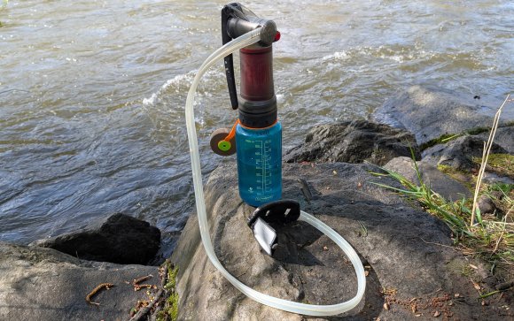 MSR Guardian pump filter perched on a nalgene with a river in the background
