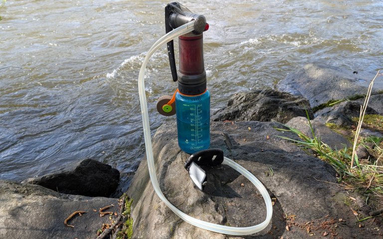 MSR Guardian pump filter perched on a nalgene with a river in the background