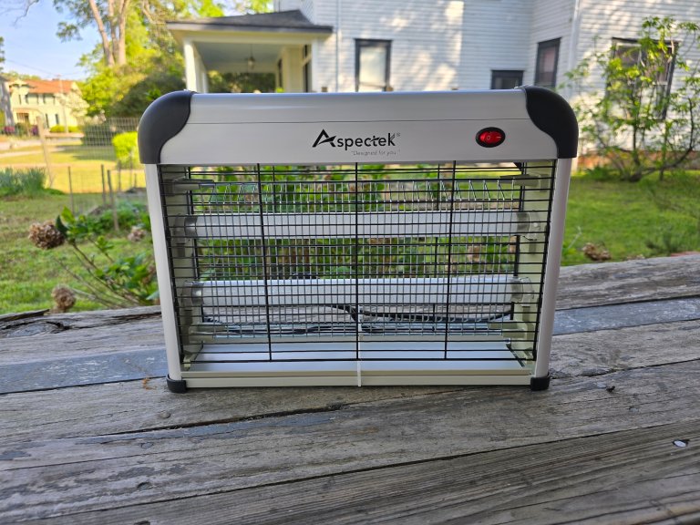 A bug zapper sits on a porch outside.