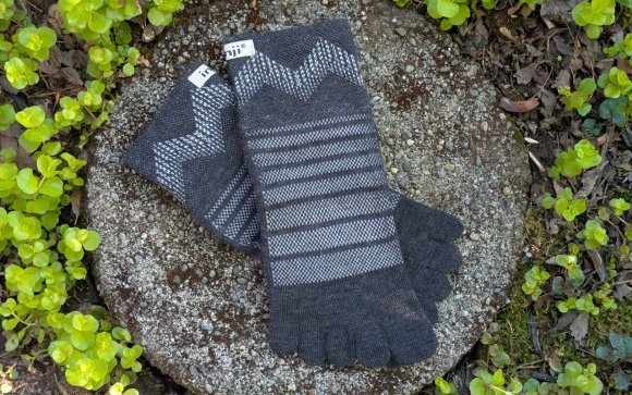 Injinji socks sitting on a round stone
