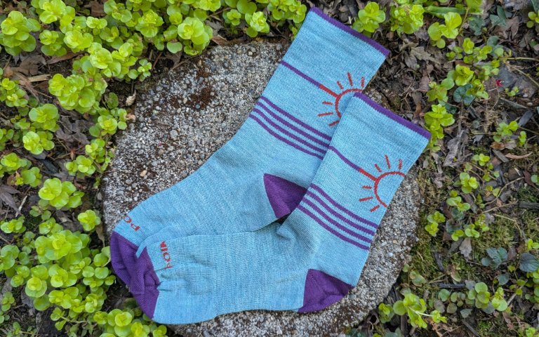 Point6 Hike socks sitting on a round stone