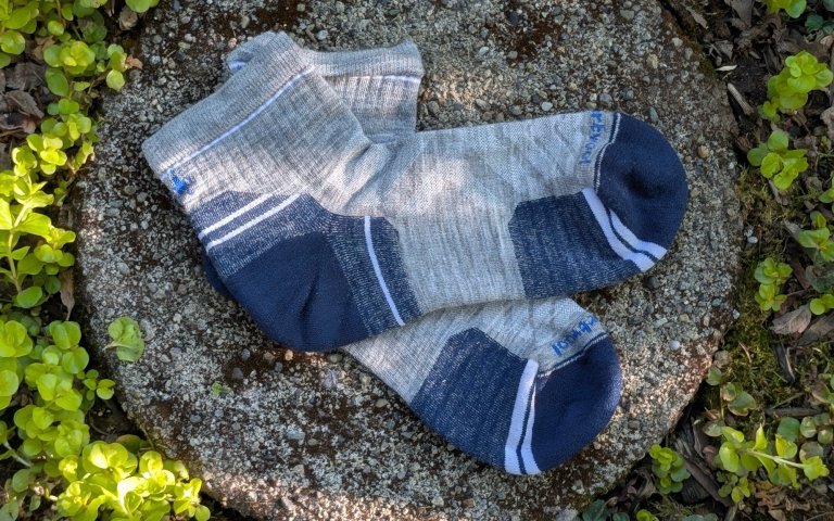 Smartwool Ankle socks sitting on a round stone