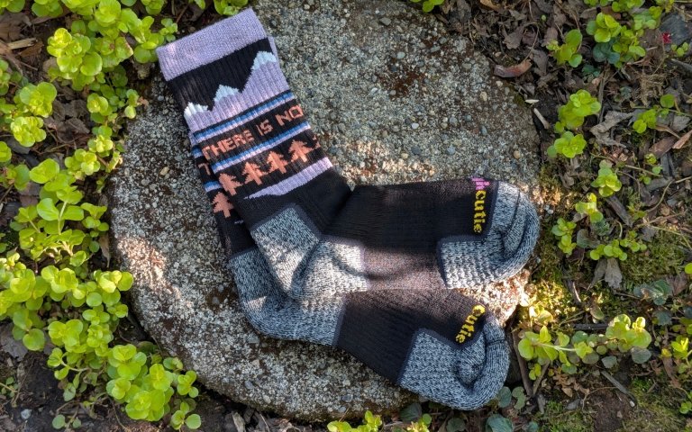 Tough Cutie socks sitting on a round stone