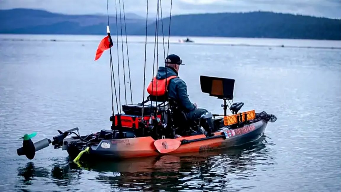 A kayak angler moves across a large lake.