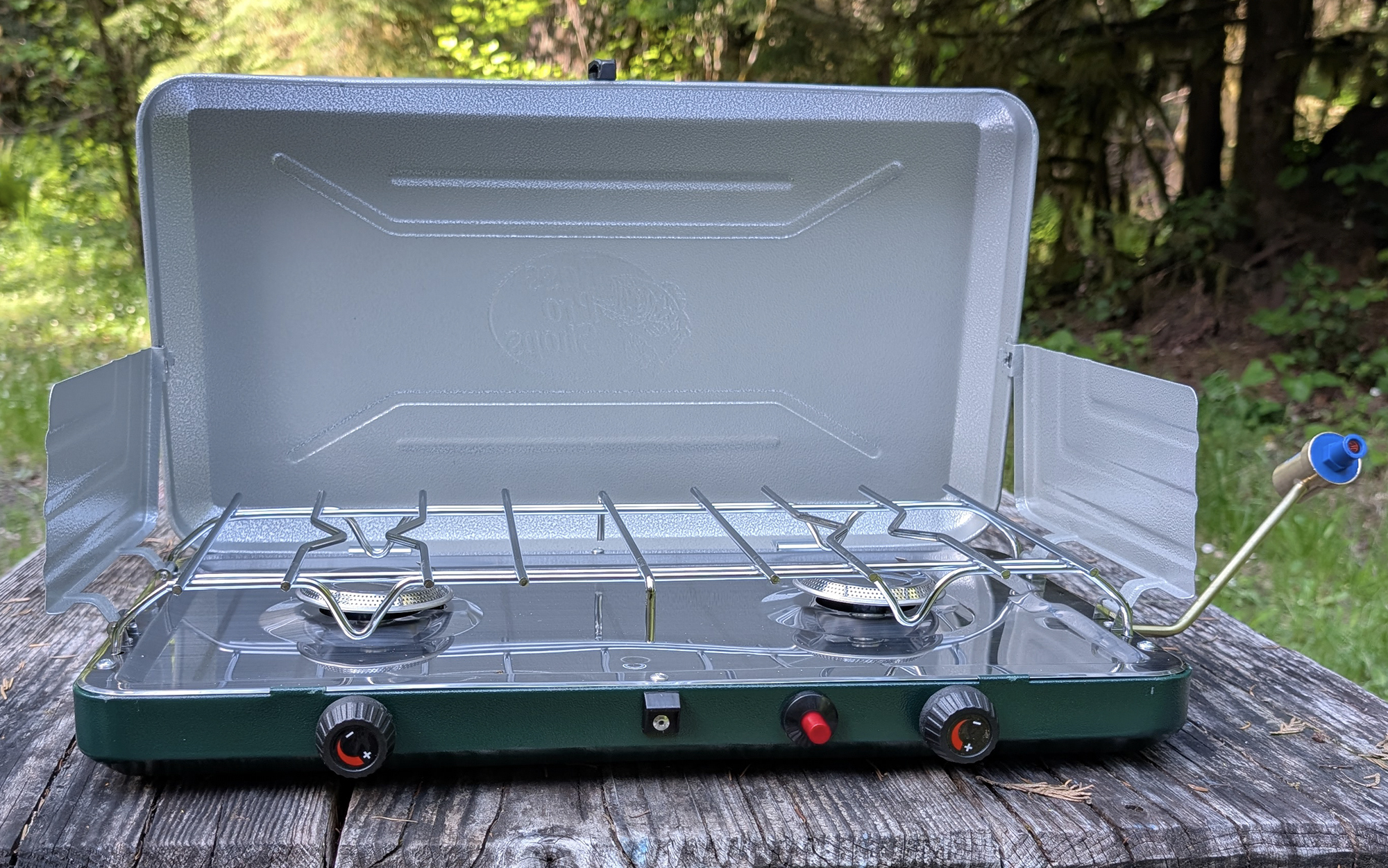 Bass Pro Shops camping stove sitting on a picnic table