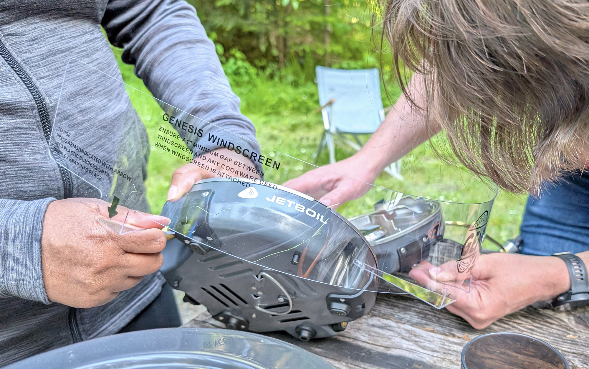 two people trying to attach the JetBoil Genesis windscreen