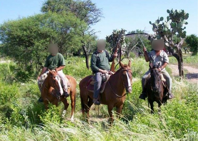Three hunters on horseback in Argentina.
