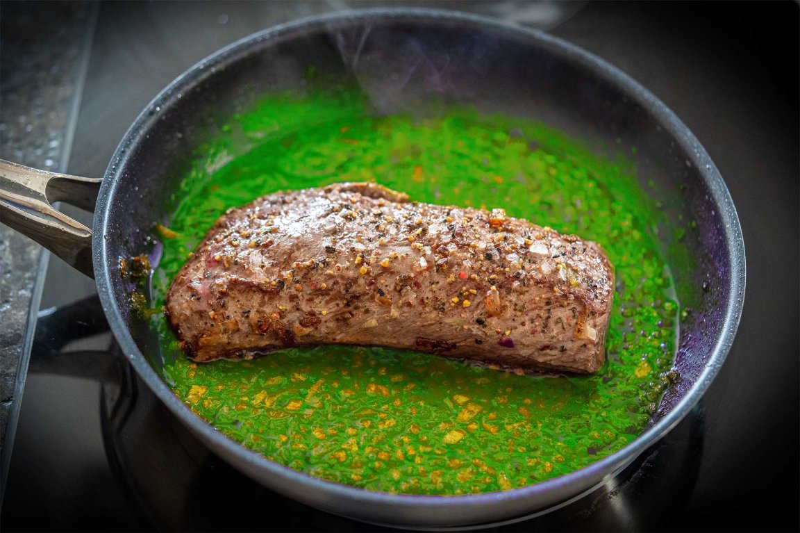 Wild venison cooking in neon green sauce to represent a story about forever chemicals in wild game meat.