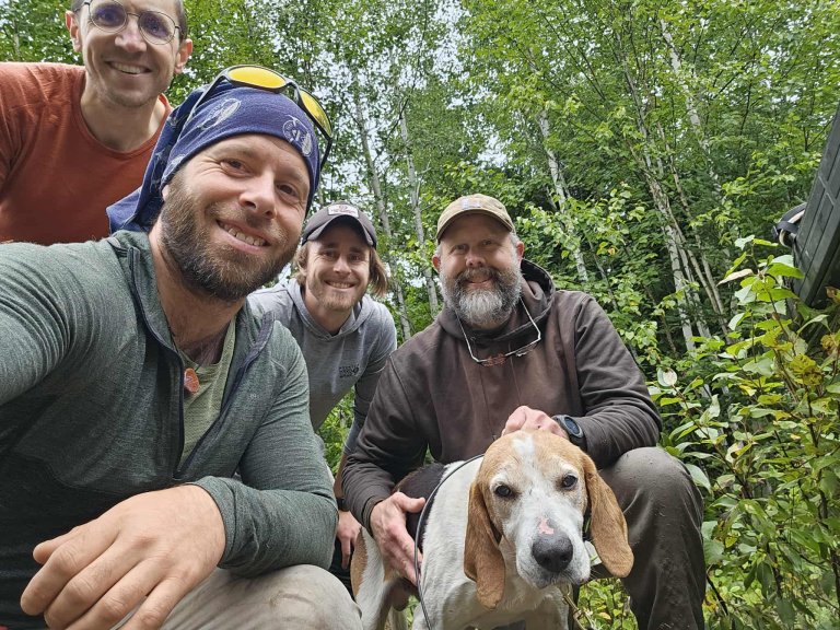 A group of four men after the rescue of Boomer the dog.
