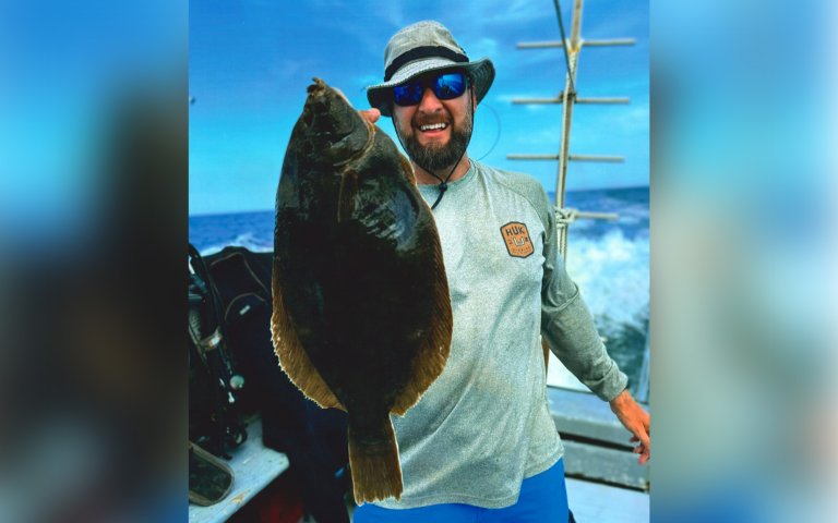 A New Jersey diver holds up a winter flounder he speared.