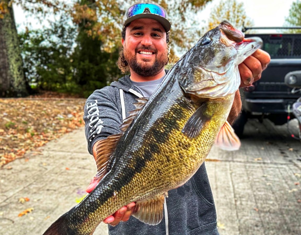 A fishing guide holds up a state-record bass in Tennessee.