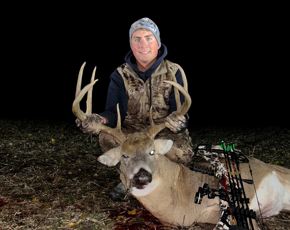 A bowhunter with an 8-point buck.