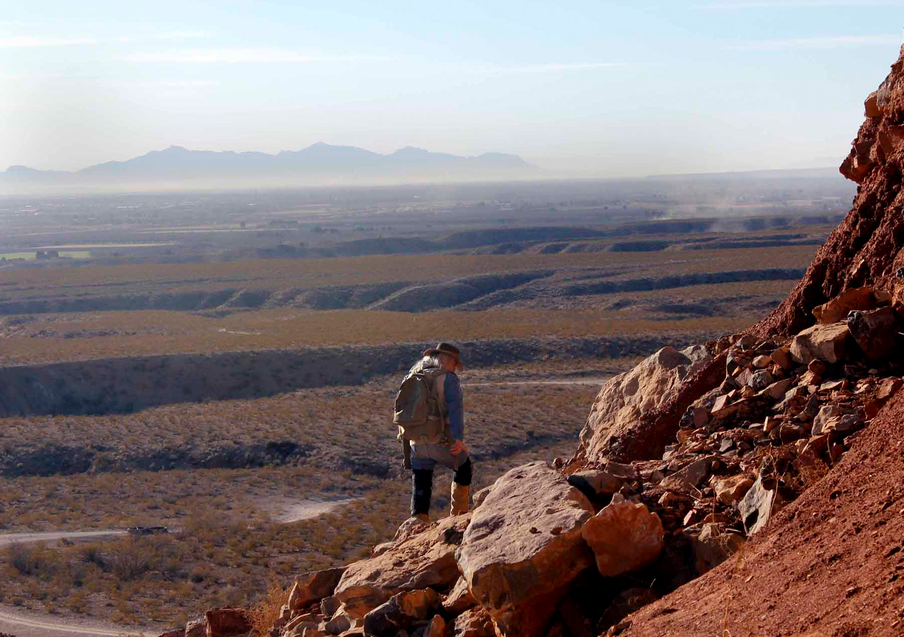 A hiker treks across desert mountains in New Mexico.
