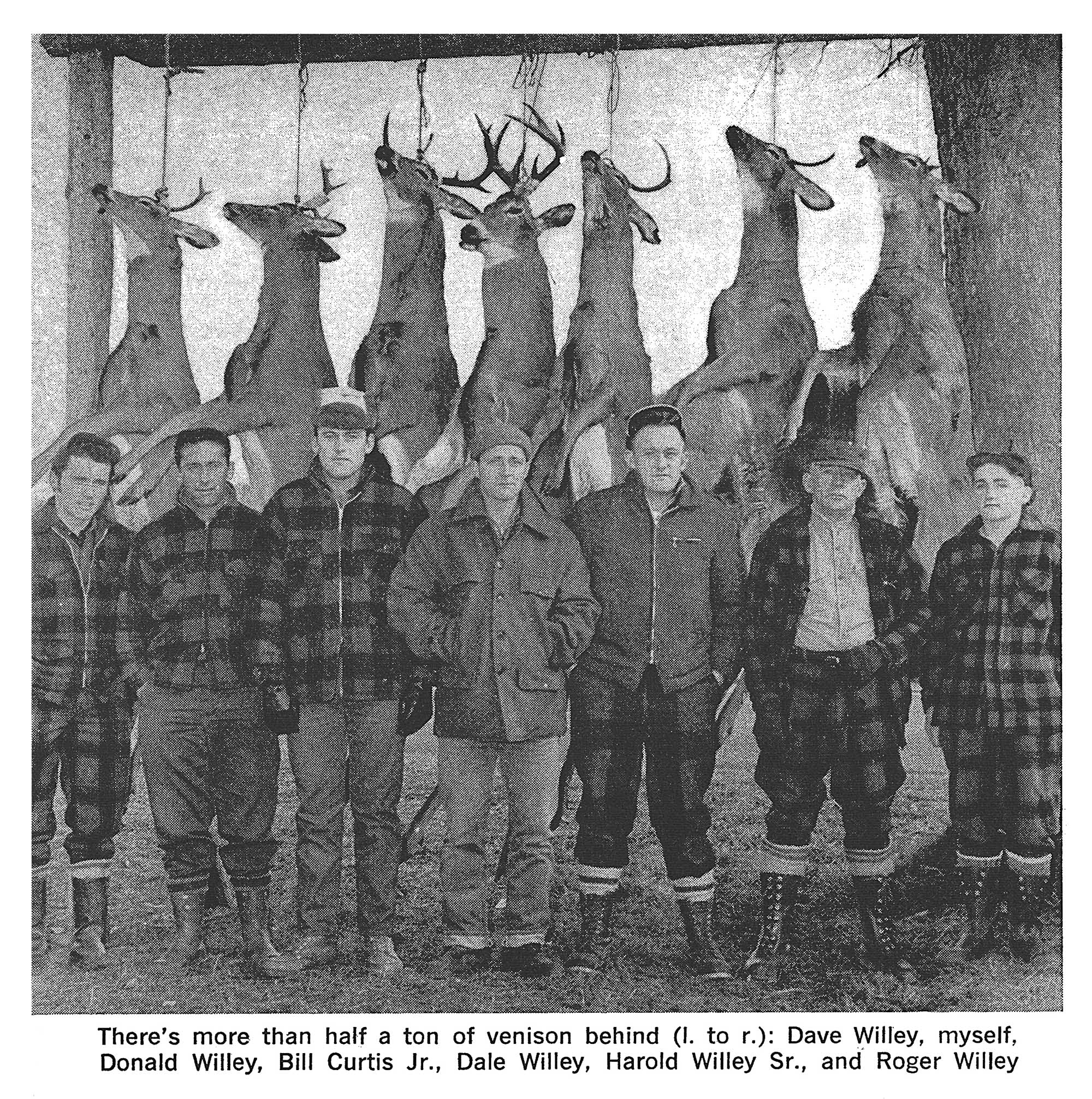 An old black and white photo of deer on a pole with hunters.