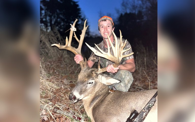 A rifle hunter with a giant Maine buck.
