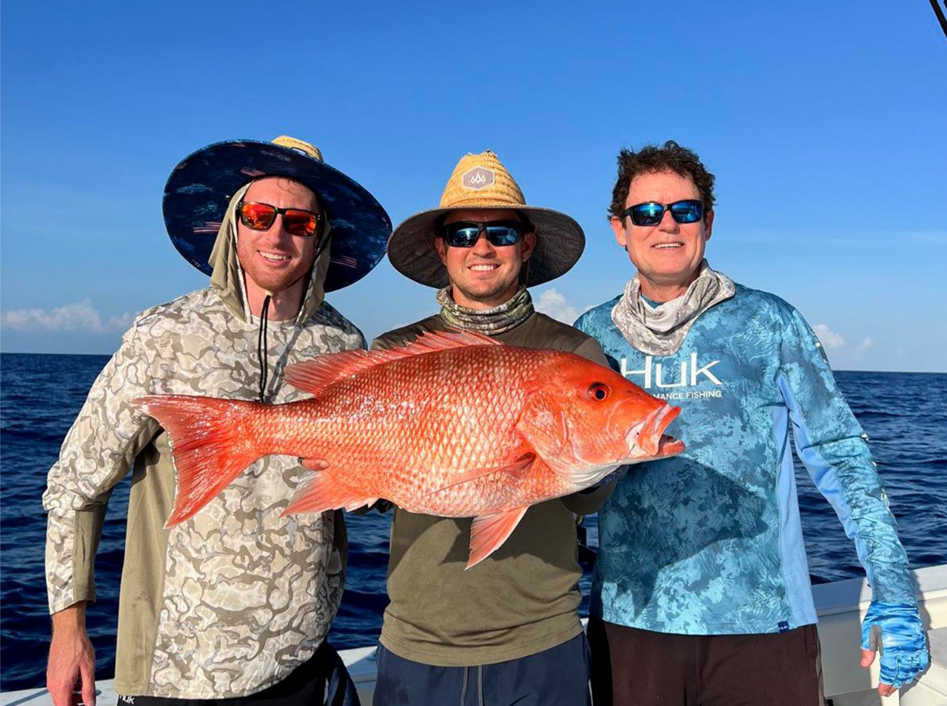 Three Florida fishermen with a big red snapper.