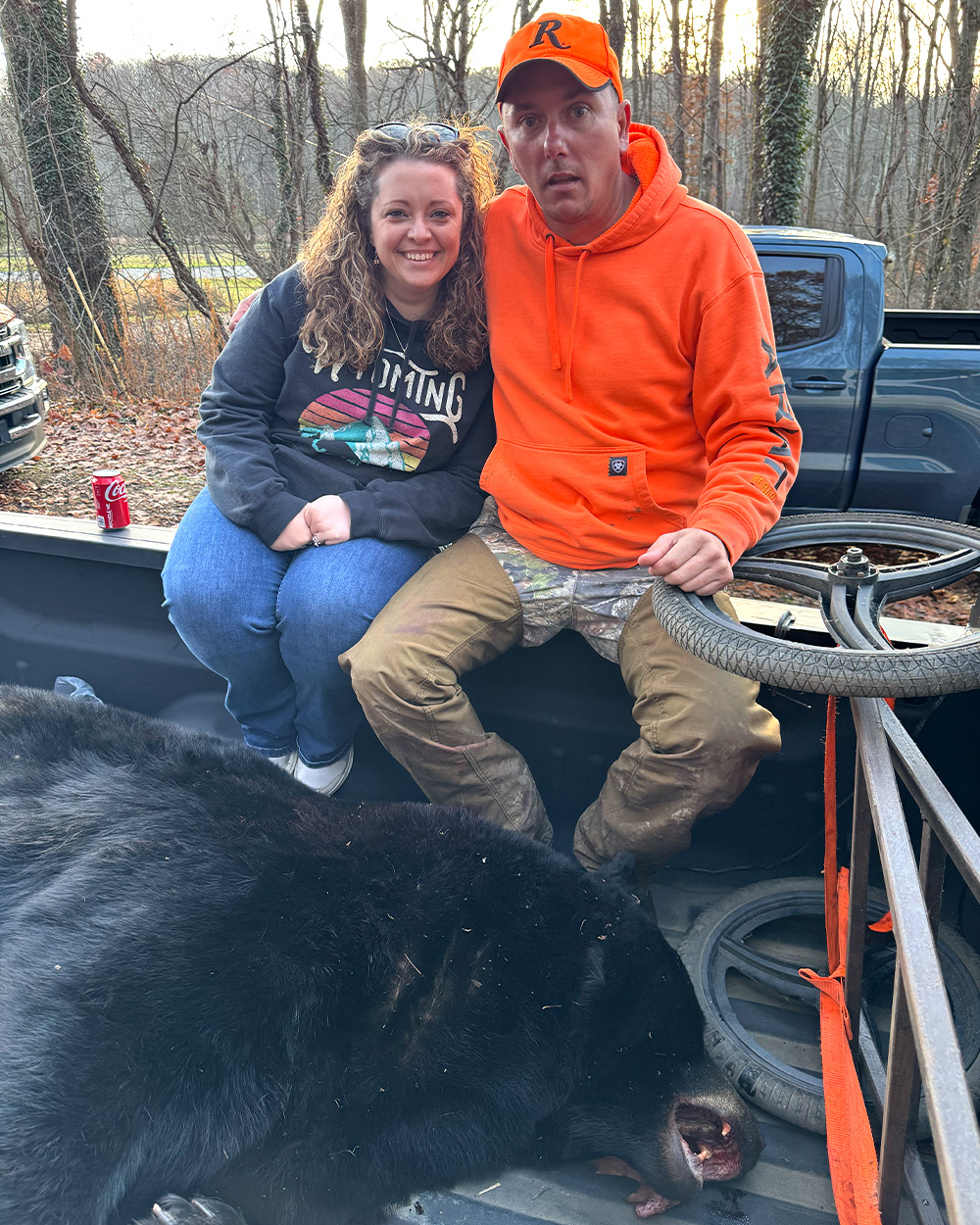 A hunter and his wife with a big black bear.