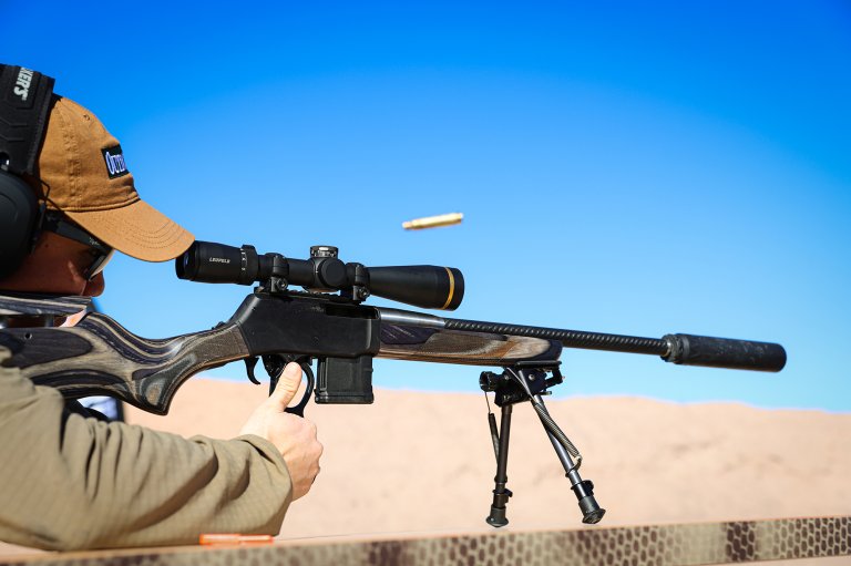 A photo of a guy shooting a carbon fiber lever action off a bipod.