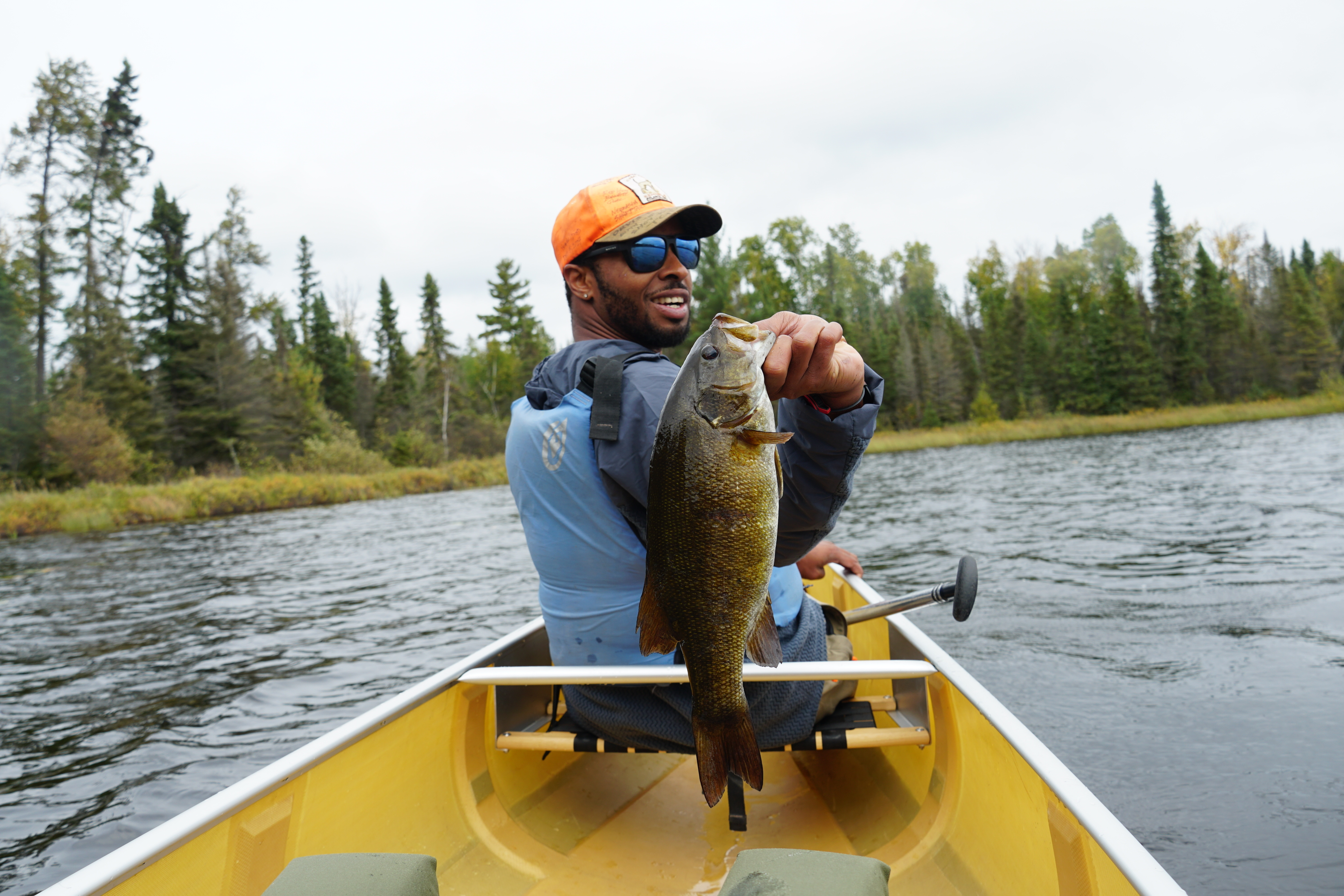 An angler holds up a smallmouth bass caught in the Boundary Waters.