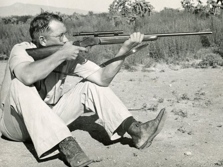 A black and white photo of Jack O'Connor shooting with a sling.
