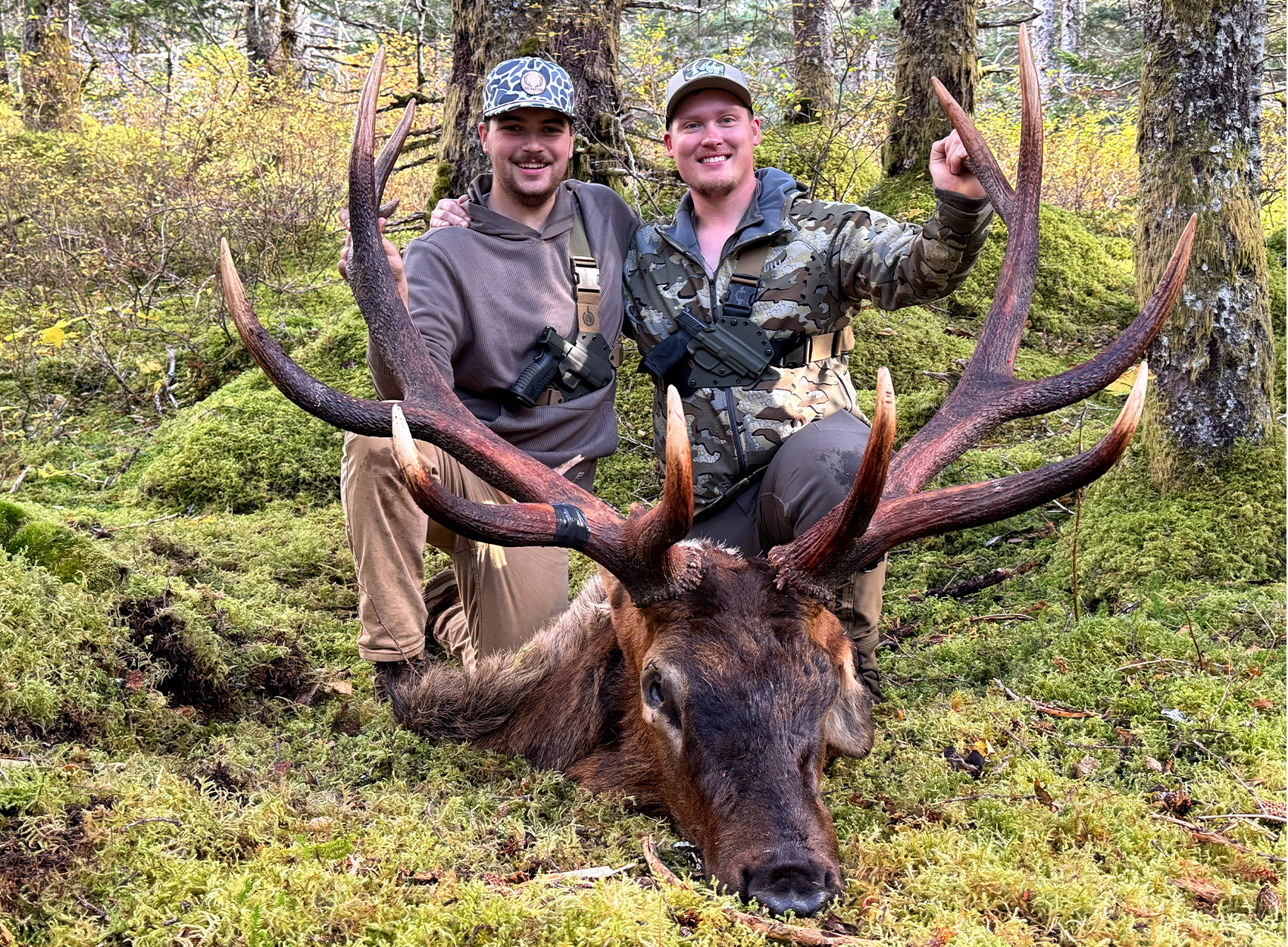 Two hunters with a huge Roosevelt bull elk.
