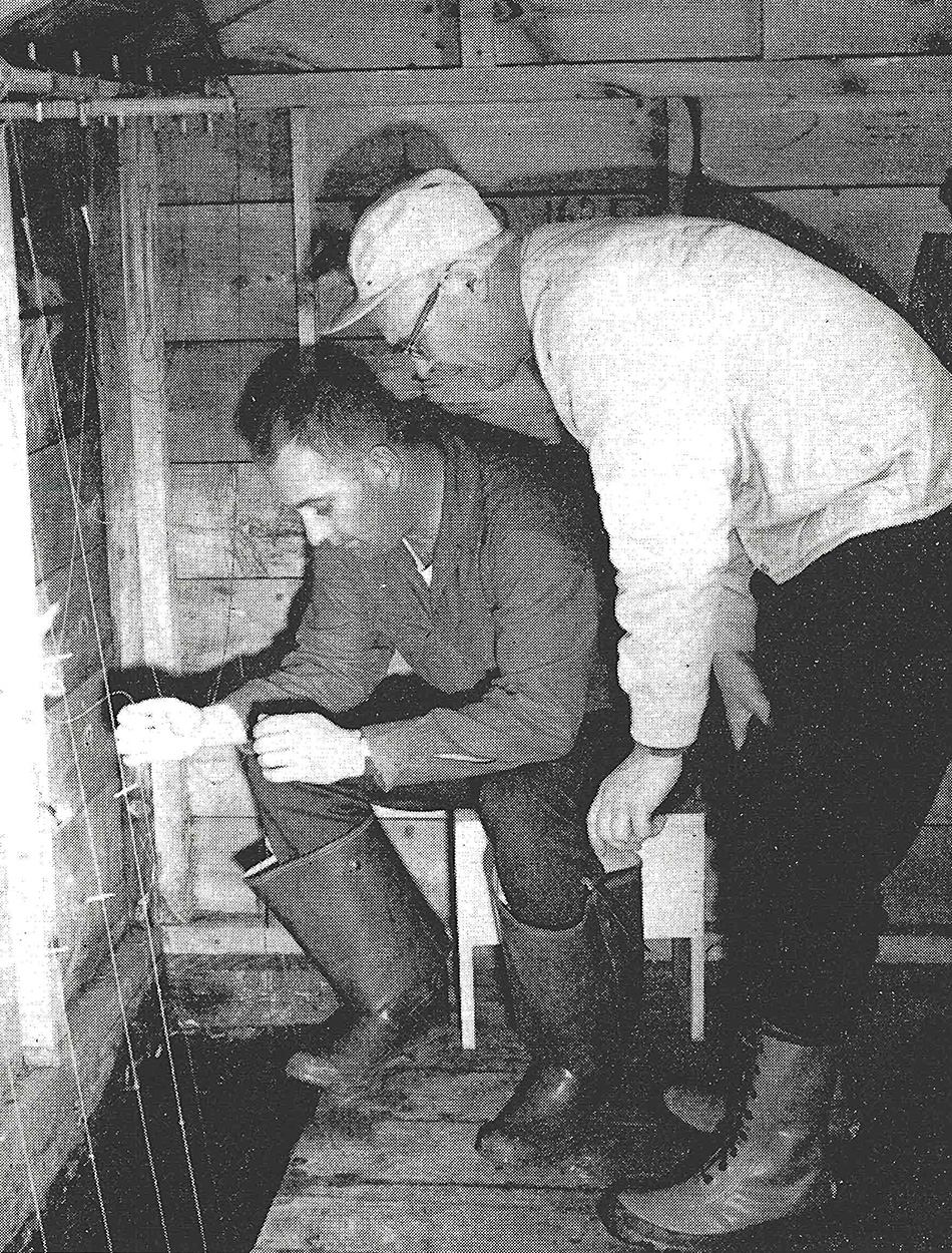 Two ice fishermen fish for smelt in Maine.