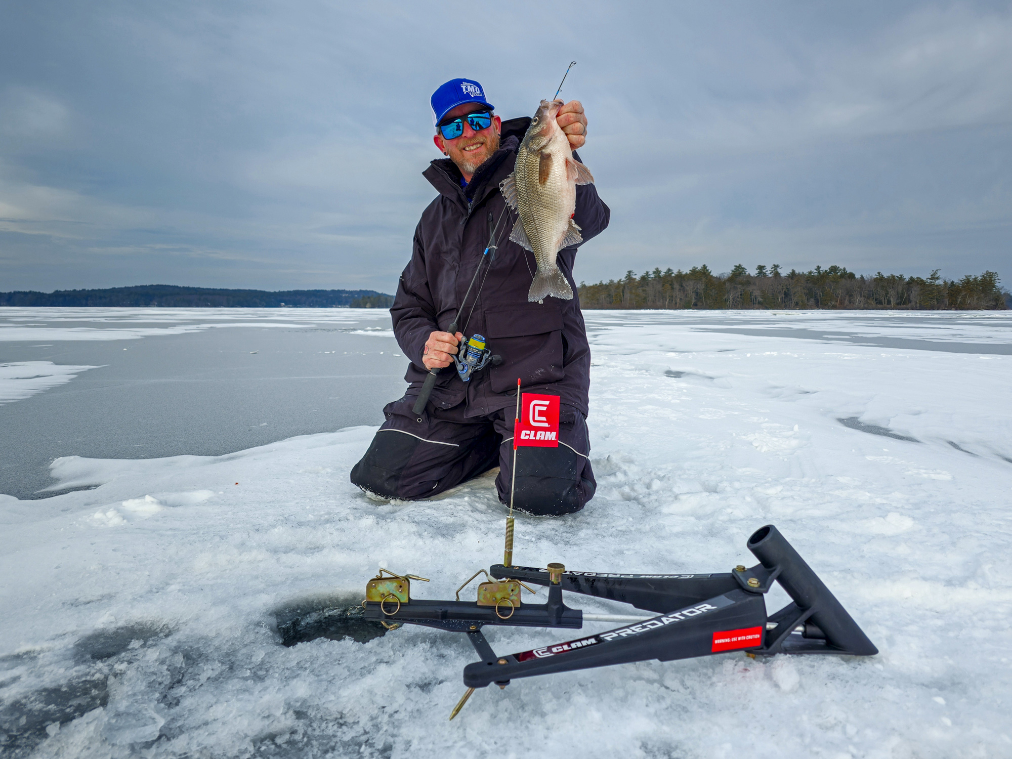 An image of an ice fisherman with a white perch.