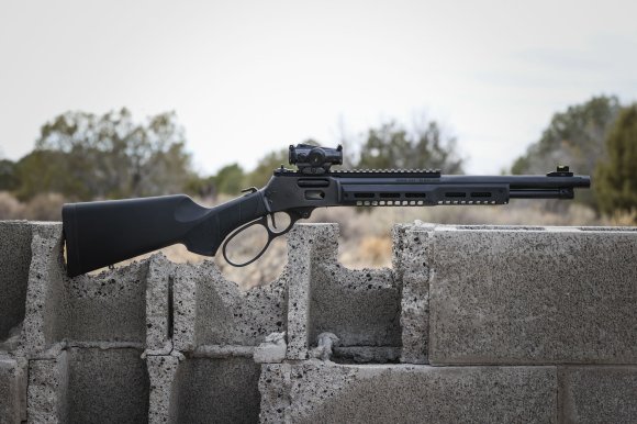 A black lever action on a breezblock wall.