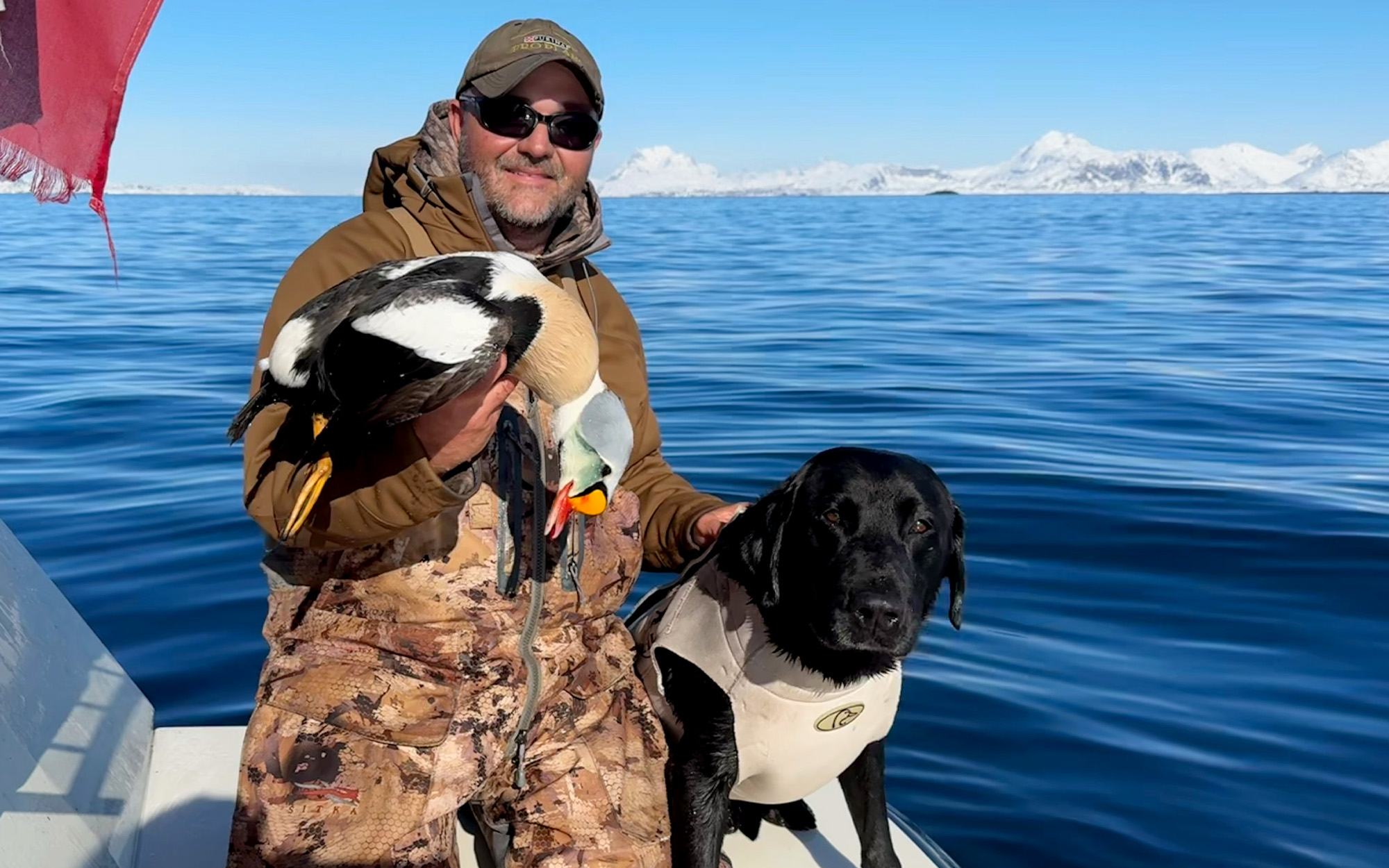 Un cazador de patos y su labrador negro de caza en Groenlandia.