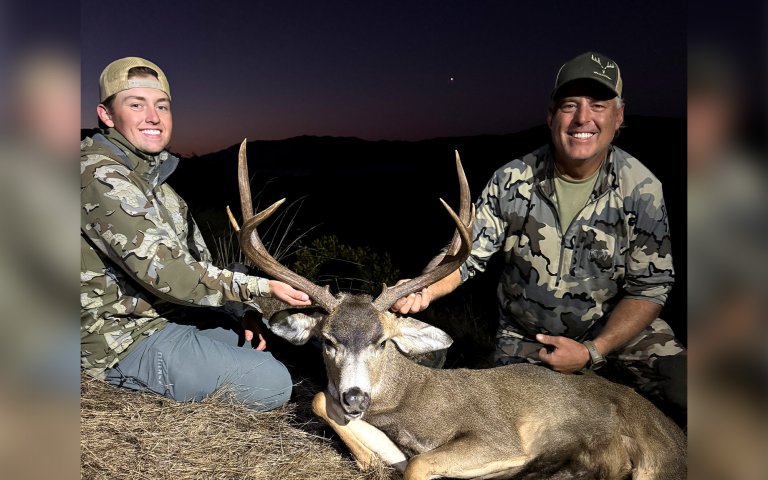 Two California hunters with a mule deer buck.